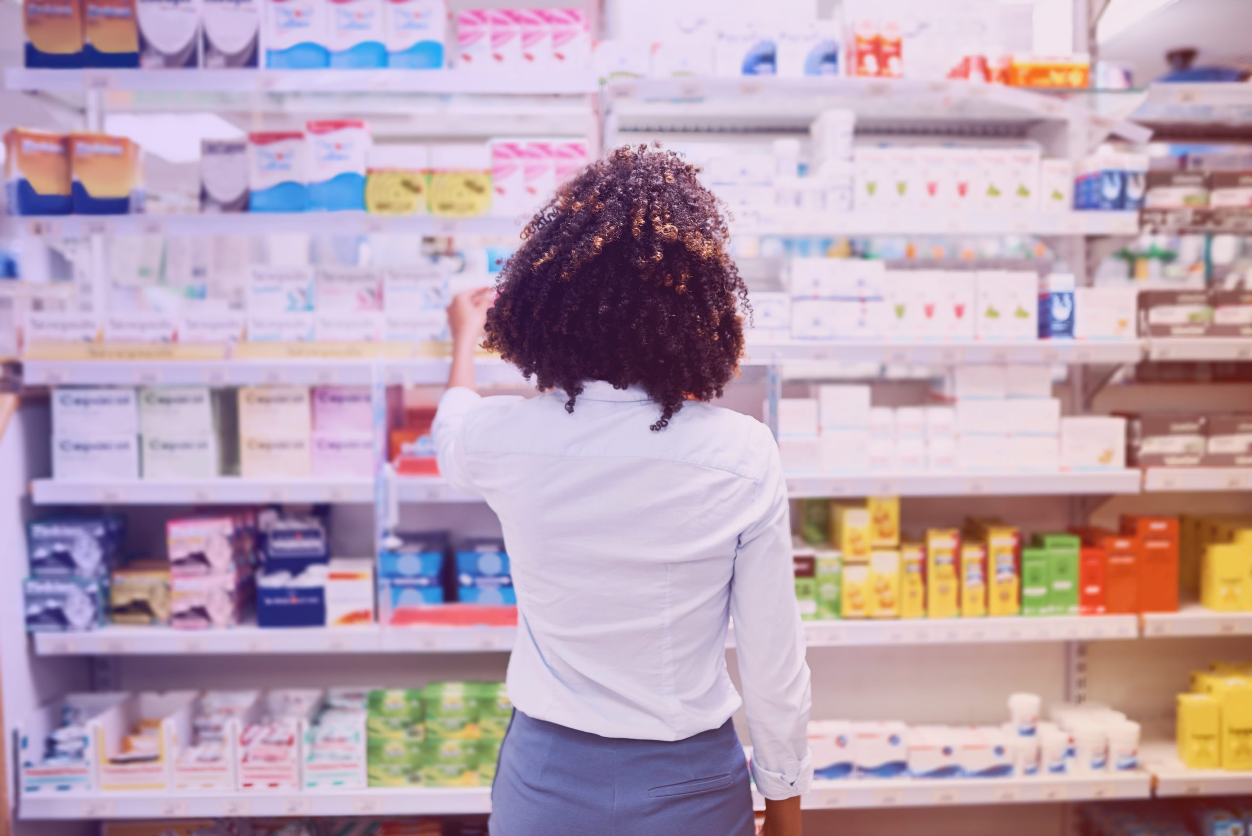 woman looks at shelf of health and wellness products